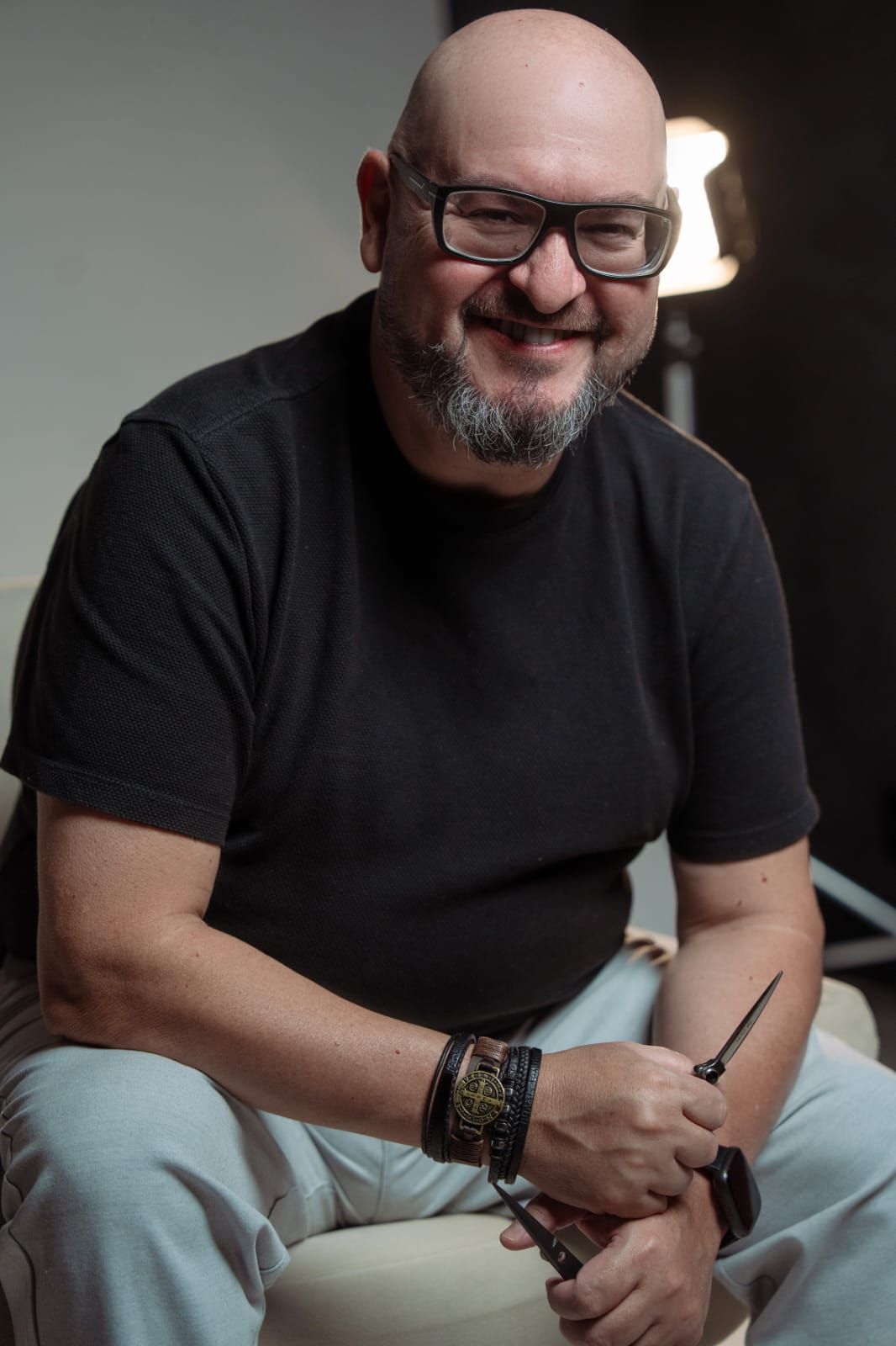 Leandro Nunes sorrindo, segurando tesoura de precisão